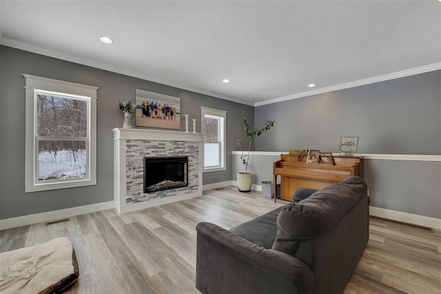 7101 Partridge Pl, Gaylord, MI 49735 - living area with crown molding, baseboards, recessed lighting, a stone fireplace, and wood finished floors