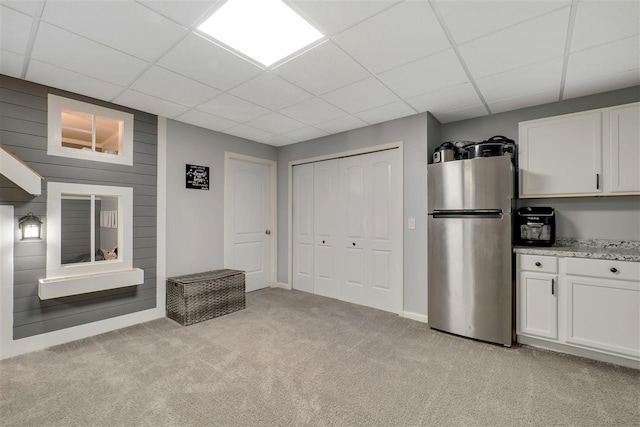 7101 Partridge Pl, Gaylord, MI 49735 - kitchen featuring freestanding refrigerator, light carpet, a drop ceiling, white cabinets, and light stone countertops