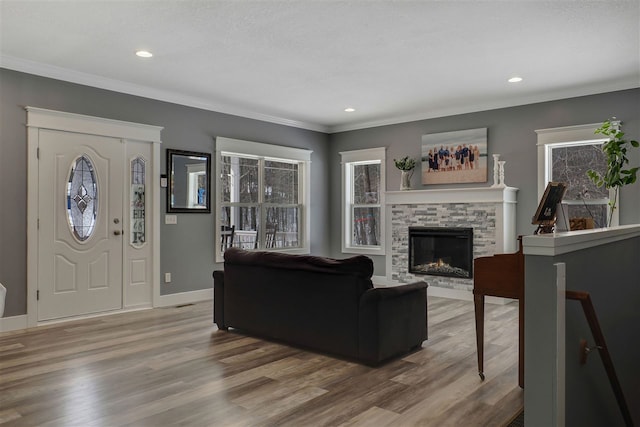 7101 Partridge Pl, Gaylord, MI 49735 - living room with a stone fireplace, wood finished floors, recessed lighting, baseboards, and ornamental molding