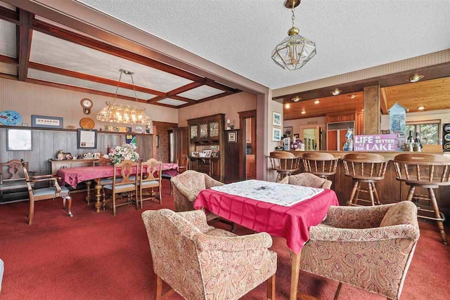 306 E Dixon Ave, Charlevoix, MI 49720 - dining room featuring carpet, beam ceiling, a chandelier, and a textured ceiling