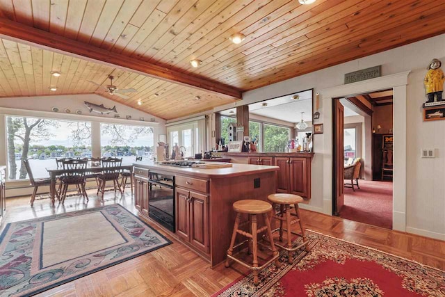 306 E Dixon Ave, Charlevoix, MI 49720 - kitchen with black oven, wood ceiling, baseboards, brown cabinets, and a ceiling fan