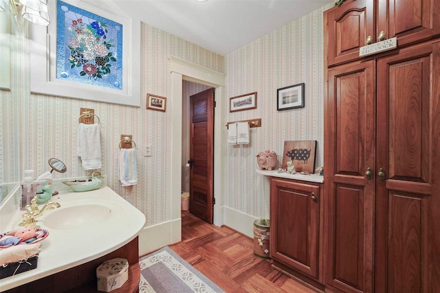 306 E Dixon Ave, Charlevoix, MI 49720 - bathroom featuring vanity, wallpapered walls, and baseboards