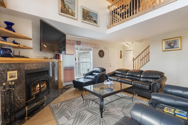4460 E Fontenoy St, Boyne City, MI 49712 - living room with wood finished floors, a towering ceiling, stairs, and a premium fireplace