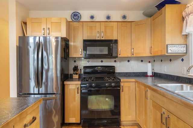 4460 E Fontenoy St, Boyne City, MI 49712 - kitchen with black appliances, a sink, dark countertops, and tasteful backsplash