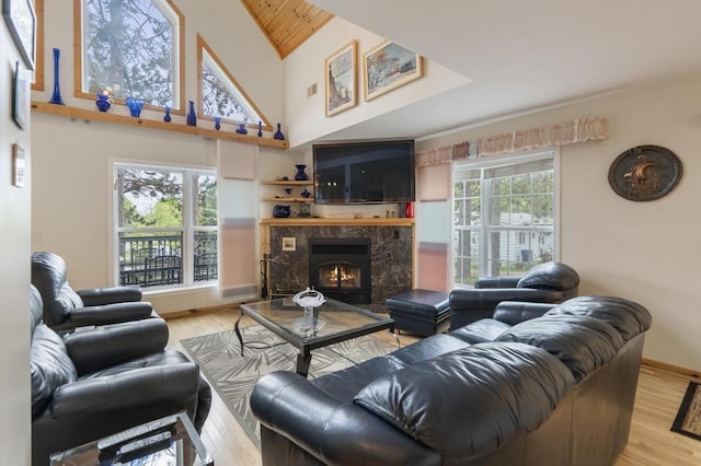 4460 E Fontenoy St, Boyne City, MI 49712 - living room with wood finished floors, a premium fireplace, high vaulted ceiling, wood ceiling, and baseboards