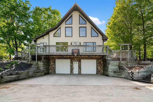 10370 Boyne City Rd, Charlevoix, MI 49720 - back of house featuring stairs, an attached garage, stone siding, a wooden deck, and driveway