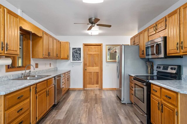 10370 Boyne City Rd, Charlevoix, MI 49720 - kitchen with stainless steel appliances, a sink, a ceiling fan, light countertops, and wood finished floors