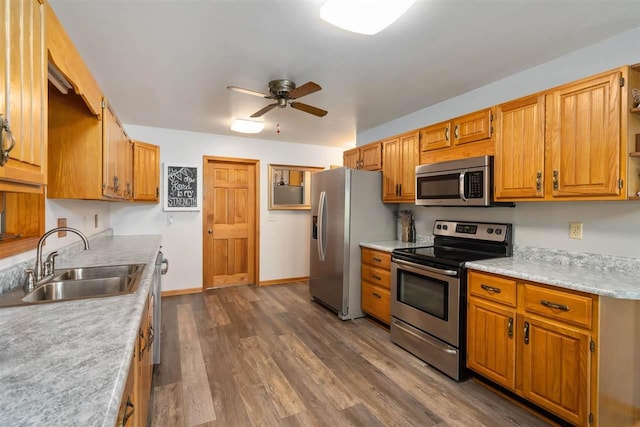 10370 Boyne City Rd, Charlevoix, MI 49720 - kitchen featuring appliances with stainless steel finishes, a sink, ceiling fan, dark wood-type flooring, and light countertops