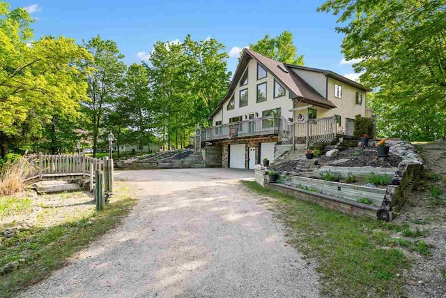 10370 Boyne City Rd, Charlevoix, MI 49720 - view of front of house featuring dirt driveway, a garage, and a deck