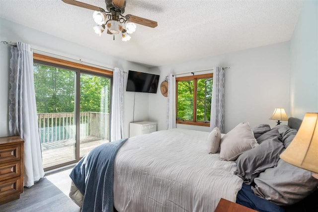10370 Boyne City Rd, Charlevoix, MI 49720 - bedroom featuring access to exterior, a textured ceiling, wood finished floors, and a ceiling fan