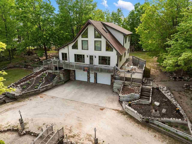 10370 Boyne City Rd, Charlevoix, MI 49720 - rustic home featuring stairs, a garage, a deck, and driveway