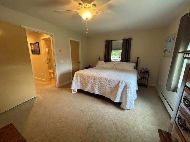 1020 Waukazoo, Petoskey, MI 49770 - carpeted bedroom with a baseboard radiator, connected bathroom, ceiling fan, and baseboards