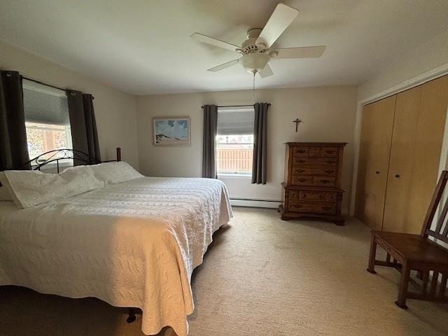 1020 Waukazoo, Petoskey, MI 49770 - bedroom featuring multiple windows, a baseboard heating unit, light colored carpet, and a closet