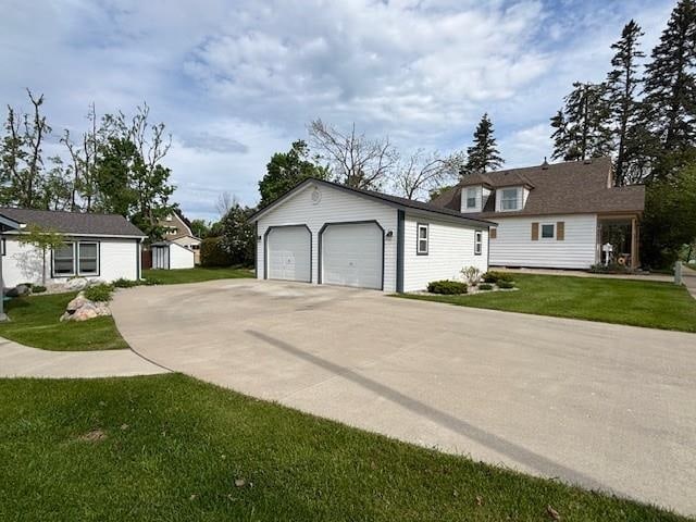 1020 Waukazoo, Petoskey, MI 49770 - view of front of property featuring an outdoor structure, a garage, and a front lawn