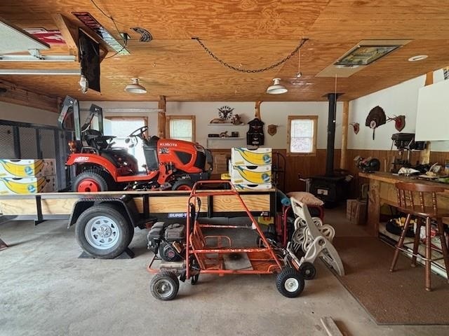 1020 Waukazoo, Petoskey, MI 49770 - garage with a wainscoted wall, wood walls, a wood stove, and wooden ceiling