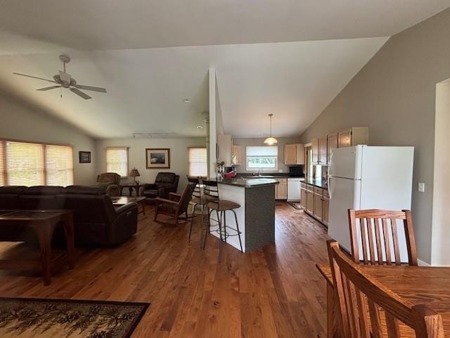 1020 Waukazoo, Petoskey, MI 49770 - kitchen featuring white appliances, vaulted ceiling, dark countertops, open floor plan, and dark wood finished floors