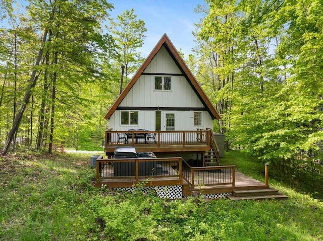 426 Chamonix Ln, Harbor Springs, MI 49740 - rear view of property with a wooden deck, board and batten siding, and a wooded view
