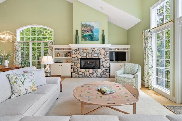 6707 Cottage Ct Unit 40, Bay Harbor, MI 49770 - living room featuring high vaulted ceiling, a chandelier, wood finished floors, and a stone fireplace