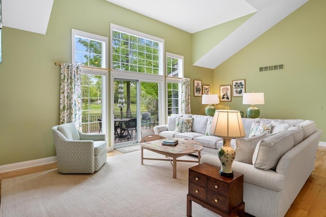 6707 Cottage Ct Unit 40, Bay Harbor, MI 49770 - living room with high vaulted ceiling, baseboards, and wood finished floors