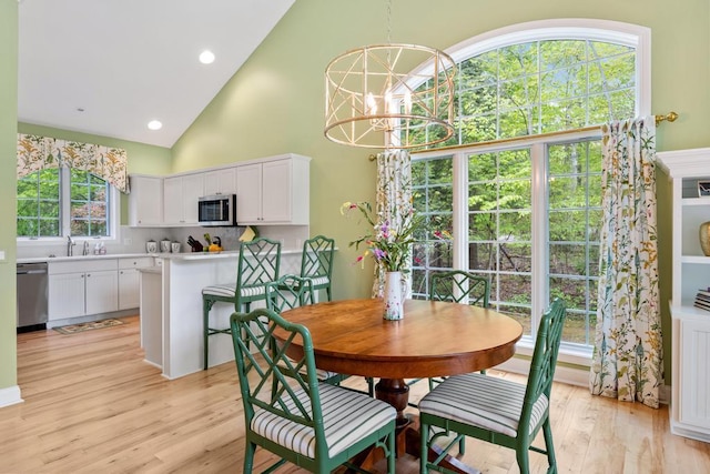 6707 Cottage Ct Unit 40, Bay Harbor, MI 49770 - dining area with high vaulted ceiling, light wood-style floors, a chandelier, and recessed lighting
