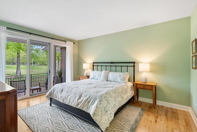 6707 Cottage Ct Unit 40, Bay Harbor, MI 49770 - bedroom with access to outside, baseboards, and light wood-style flooring
