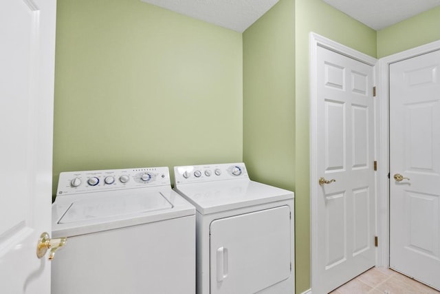 6707 Cottage Ct Unit 40, Bay Harbor, MI 49770 - washroom with separate washer and dryer and light tile patterned floors