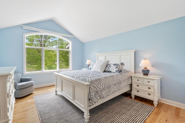 6707 Cottage Ct Unit 40, Bay Harbor, MI 49770 - bedroom with light wood finished floors, baseboards, and lofted ceiling
