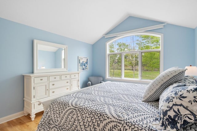 6707 Cottage Ct Unit 40, Bay Harbor, MI 49770 - bedroom with light wood-style floors, lofted ceiling, and baseboards