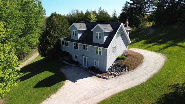 02022 Spayde Rd, Charlevoix, MI 49720 - view of front of house featuring driveway, a chimney, and a front yard