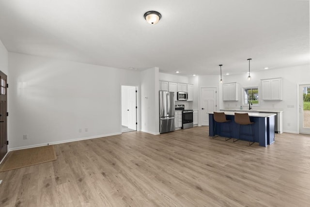 7748 Sophies Way, Harbor Springs, MI 49740 - unfurnished living room with light wood-style floors, a sink, baseboards, and recessed lighting