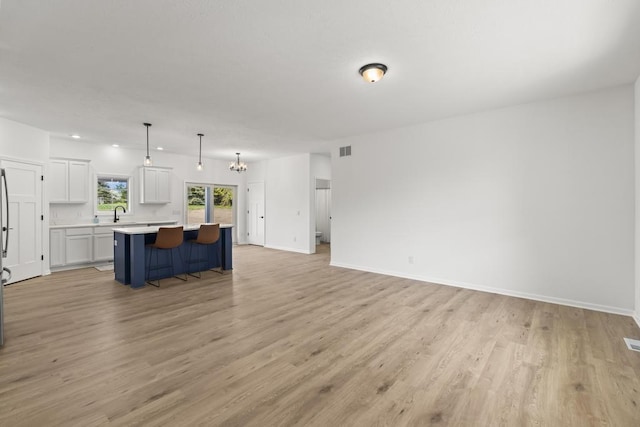 7748 Sophies Way, Harbor Springs, MI 49740 - unfurnished living room featuring light wood-style floors and baseboards