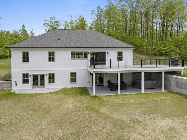 7524 Stutsmanville Rd, Harbor Springs, MI 49740 - rear view of house featuring french doors, a patio, a yard, a wooden deck, and roof with shingles