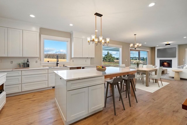 1827 Farmview, Petoskey, MI 49770 - kitchen with a sink, a chandelier, a large fireplace, open floor plan, and a kitchen island