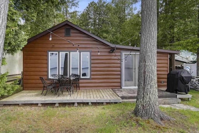 21677 Bluffs Hwy, Onaway, MI 49765 - back of house featuring a wooden deck and a lawn