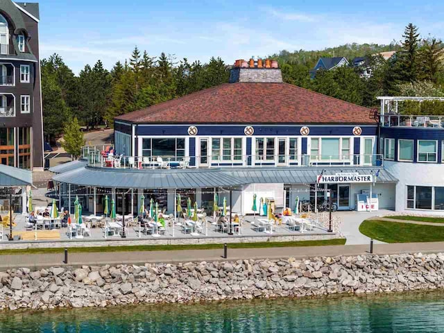 824 Vista Dr Unit 64, Bay Harbor, MI 49770 - rear view of house featuring a chimney and a water view