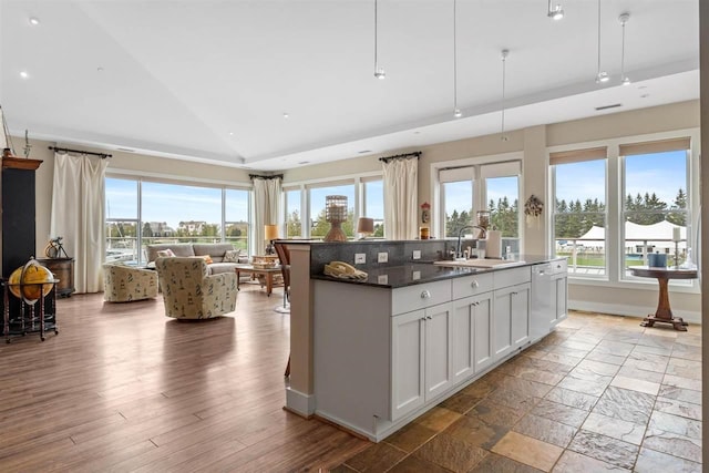 824 Vista Dr Unit 64, Bay Harbor, MI 49770 - kitchen featuring a sink, vaulted ceiling, open floor plan, plenty of natural light, and a kitchen island with sink