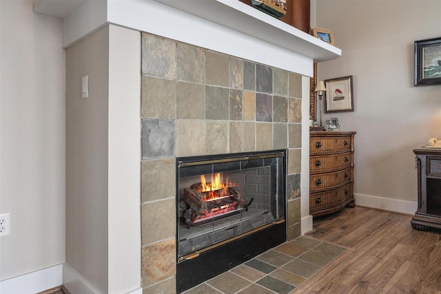 824 Vista Dr Unit 64, Bay Harbor, MI 49770 - detailed view of a tile fireplace, baseboards, and wood finished floors