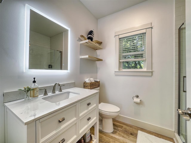 103 Riverwalk Ln Unit 103, Charlevoix, MI 49720 - bathroom with wood finished floors, toilet, vanity, and a shower with door