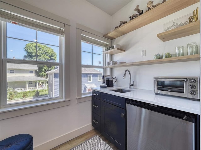 103 Riverwalk Ln Unit 103, Charlevoix, MI 49720 - kitchen featuring open shelves, a sink, stainless steel dishwasher, wood finished floors, and light countertops