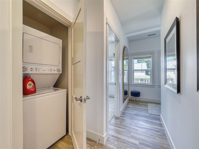 103 Riverwalk Ln Unit 103, Charlevoix, MI 49720 - laundry room featuring stacked washer / drying machine, light wood-type flooring, and baseboards