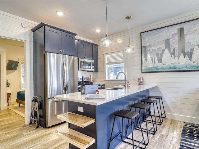 103 Riverwalk Ln Unit 103, Charlevoix, MI 49720 - kitchen featuring stainless steel appliances, light wood-type flooring, a kitchen breakfast bar, a sink, and a peninsula
