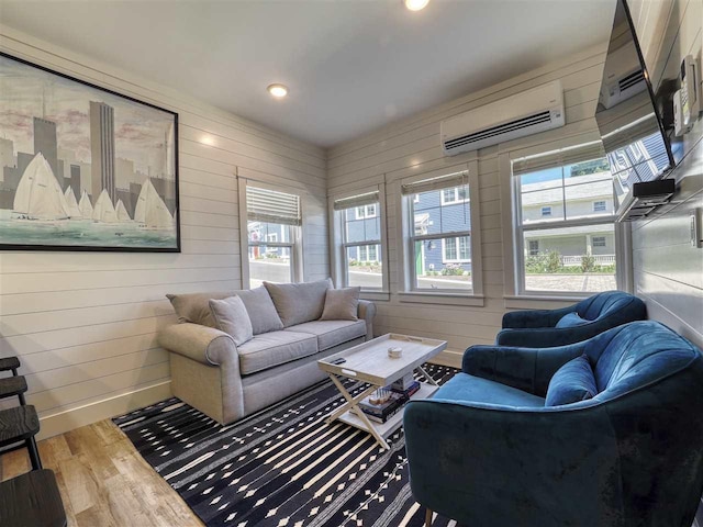 103 Riverwalk Ln Unit 103, Charlevoix, MI 49720 - living area featuring a wall mounted AC, wood finished floors, plenty of natural light, baseboards, and recessed lighting