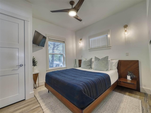 103 Riverwalk Ln Unit 103, Charlevoix, MI 49720 - bedroom featuring wood finished floors, baseboards, and a ceiling fan