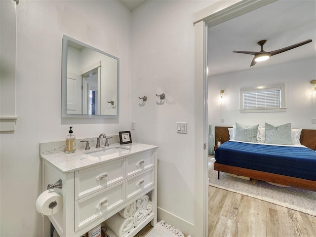 103 Riverwalk Ln Unit 103, Charlevoix, MI 49720 - bathroom featuring wood finished floors, vanity, ensuite bath, a ceiling fan, and baseboards
