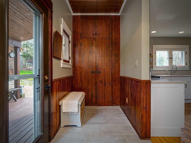 7671 Hoyt Rd, Harbor Springs, MI 49740 - doorway to outside with wood walls, wainscoting, a sink, ornamental molding, and recessed lighting