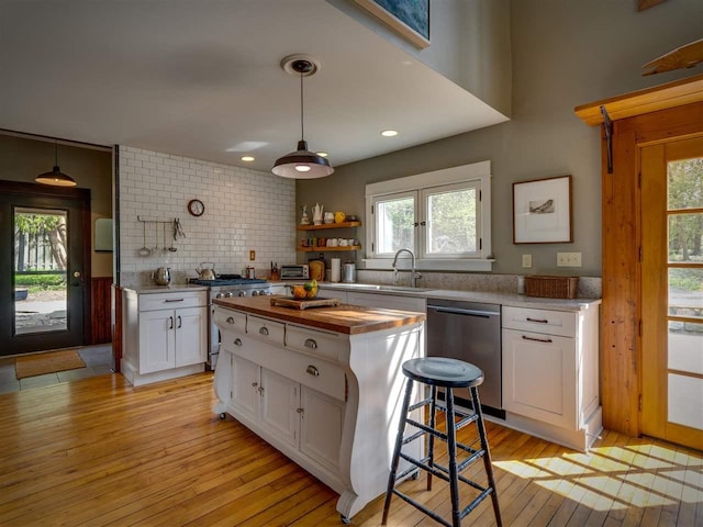 7671 Hoyt Rd, Harbor Springs, MI 49740 - kitchen featuring appliances with stainless steel finishes, wooden counters, a sink, white cabinets, and healthy amount of natural light