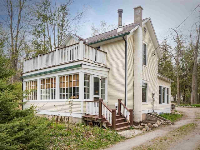 7671 Hoyt Rd, Harbor Springs, MI 49740 - back of property featuring a balcony and a chimney