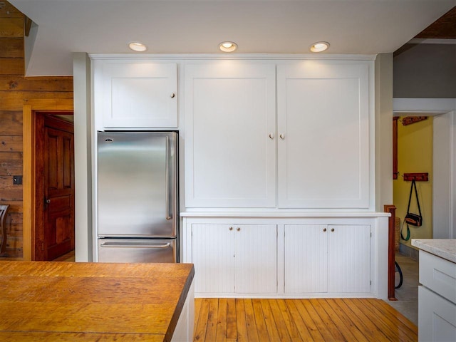 7671 Hoyt Rd, Harbor Springs, MI 49740 - kitchen with high end refrigerator, white cabinets, light countertops, light wood-style flooring, and recessed lighting