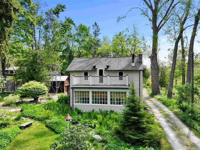 7671 Hoyt Rd, Harbor Springs, MI 49740 - rear view of house with dirt driveway, a chimney, and a balcony