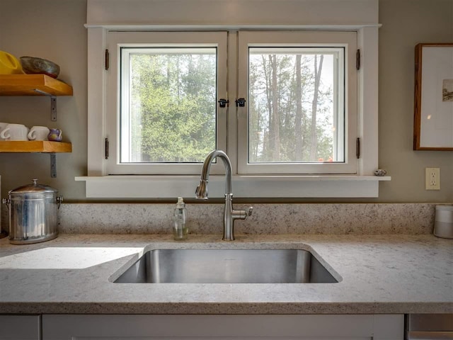 7671 Hoyt Rd, Harbor Springs, MI 49740 - kitchen view of a sink, white cabinets, light stone countertops, and open shelves